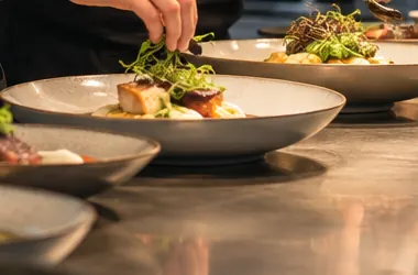 Angerichteter Teller mit Fischfilet und Kräutersalat